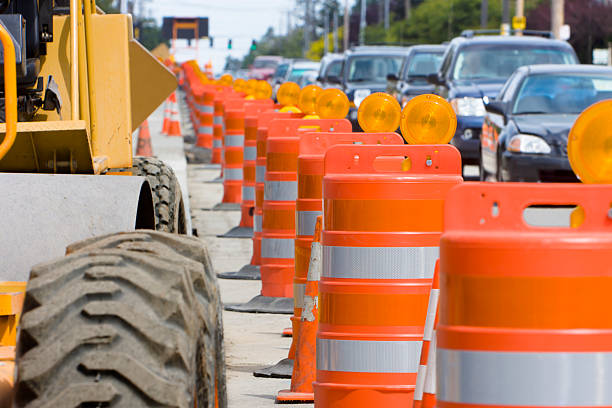The construction led to a lot of traffic A row of bright Orange construction barriers separate construction from the busy traffic. barricade stock pictures, royalty-free photos & images