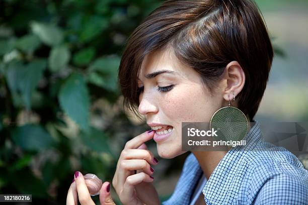 Mujer Aplicar Gloss De Labios Foto de stock y más banco de imágenes de Cabello corto - Cabello corto, Mujeres, Perfil - Vista de costado