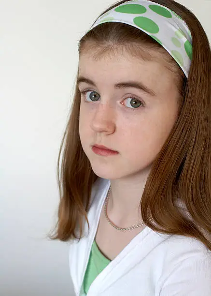 "A young teenage girl is pretty with her Irish heritage coloring of green eyes, chestnut hair and fair, freckled skin"