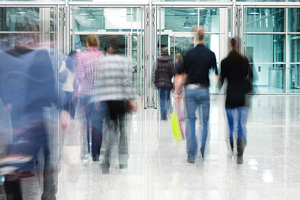 istock Blurred People Walking Toward Glass Doorway 182182912