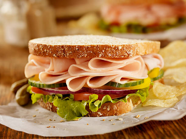 Smoked Turkey Sandwich "Smoked Turkey Sandwich on Whole Grain Bread with Lettuce, Tomatoes, Cucumbers, Red Onions, Yellow Peppers and Potato Chips on the Side- Photographed on Hasselblad H3D2-39mb Camera" sandwich stock pictures, royalty-free photos & images