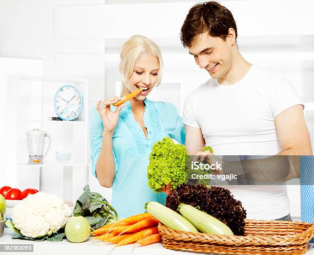 Foto de Casal Jovem Cozinhar E Se Divertindo Na Cozinha e mais fotos de stock de Abraçar - Abraçar, Adulto, Alimentação Saudável