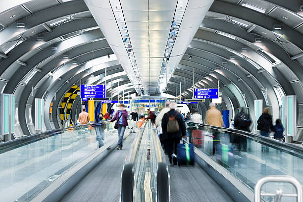 i viaggiatori in passerella scorrevole in aeroporto - urgency speed construction walking foto e immagini stock