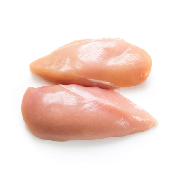 Two raw chicken breasts on a white background "Skinless, boneless, raw chicken breast, isolated on white. Selective focus.SEE MY PORTFOLIO FOR MANY VARIATIONS AND FOOD IMAGES." chicken breast photos stock pictures, royalty-free photos & images