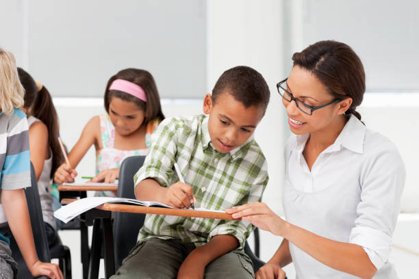 istock Teacher helping an African American boy with school work 182184360