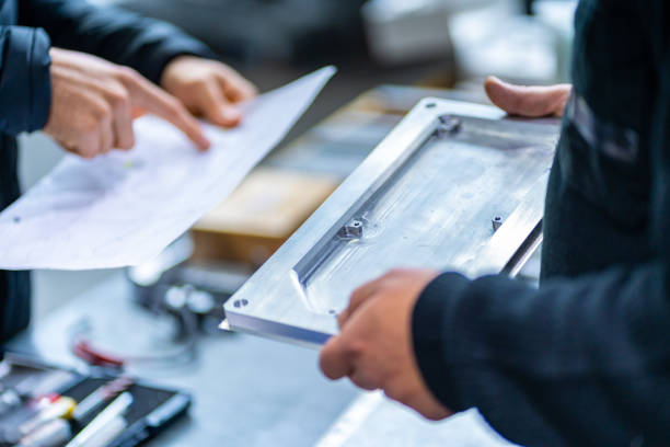 Close-up of engineers working on cnc factory examining pieces