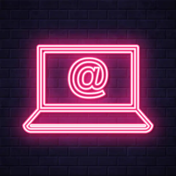 Vector illustration of Laptop with At symbol. Glowing neon icon on brick wall background