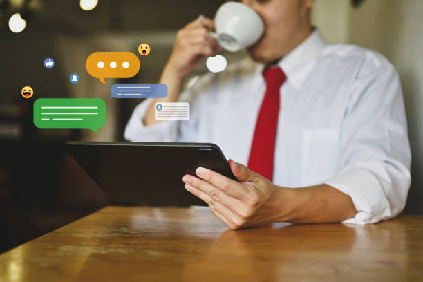 istock Young businessman drinking hot coffee using digital tablet with icons social media 1821868789