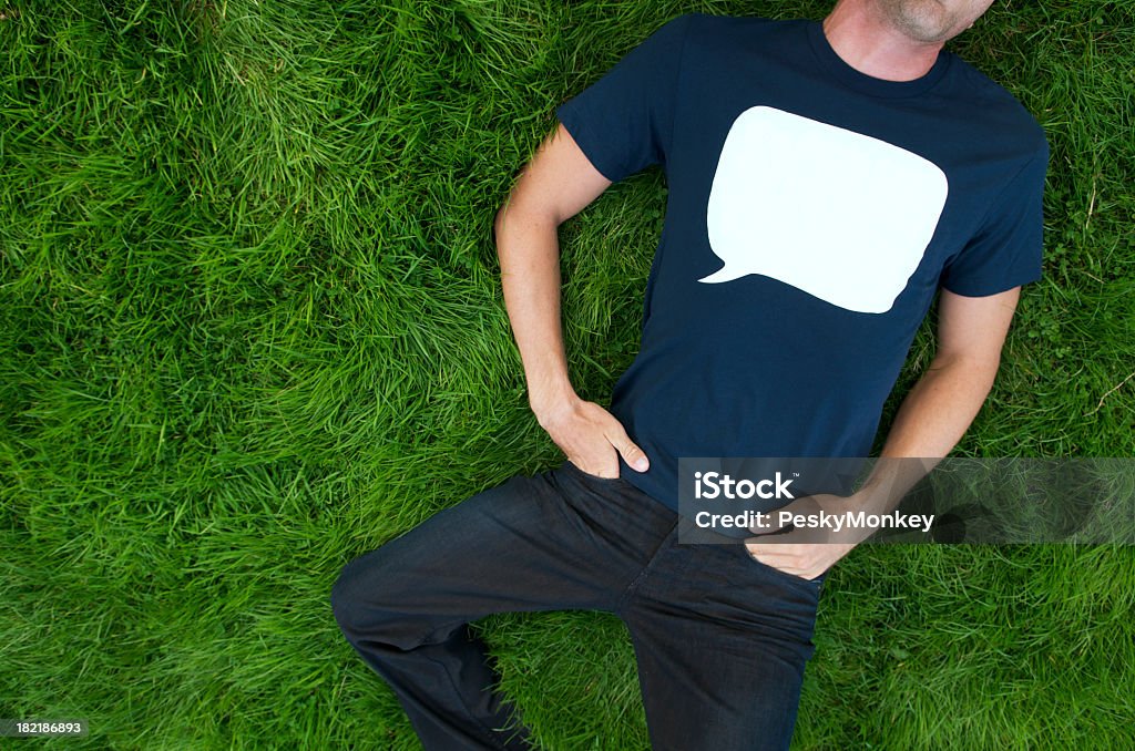 Blaues T-Shirt Sprechblase Mann liegt auf Gras im Freien - Lizenzfrei Männer Stock-Foto