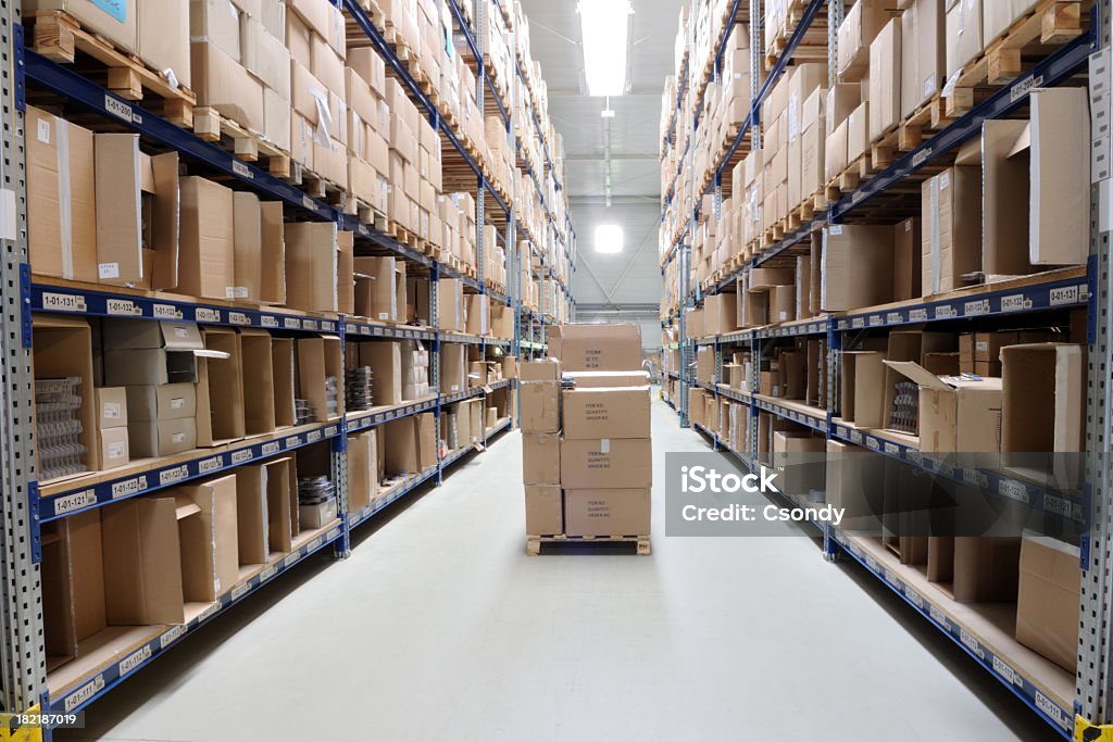 Warehouse Indoor manufacturing and storage details. Warehouse aisle with shelving, cardboard boxes and other merchandise. Box - Container Stock Photo