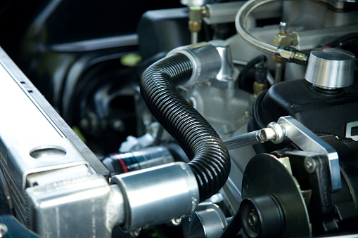 A close-up shot of a Coolant line etc. in an engine compartment.