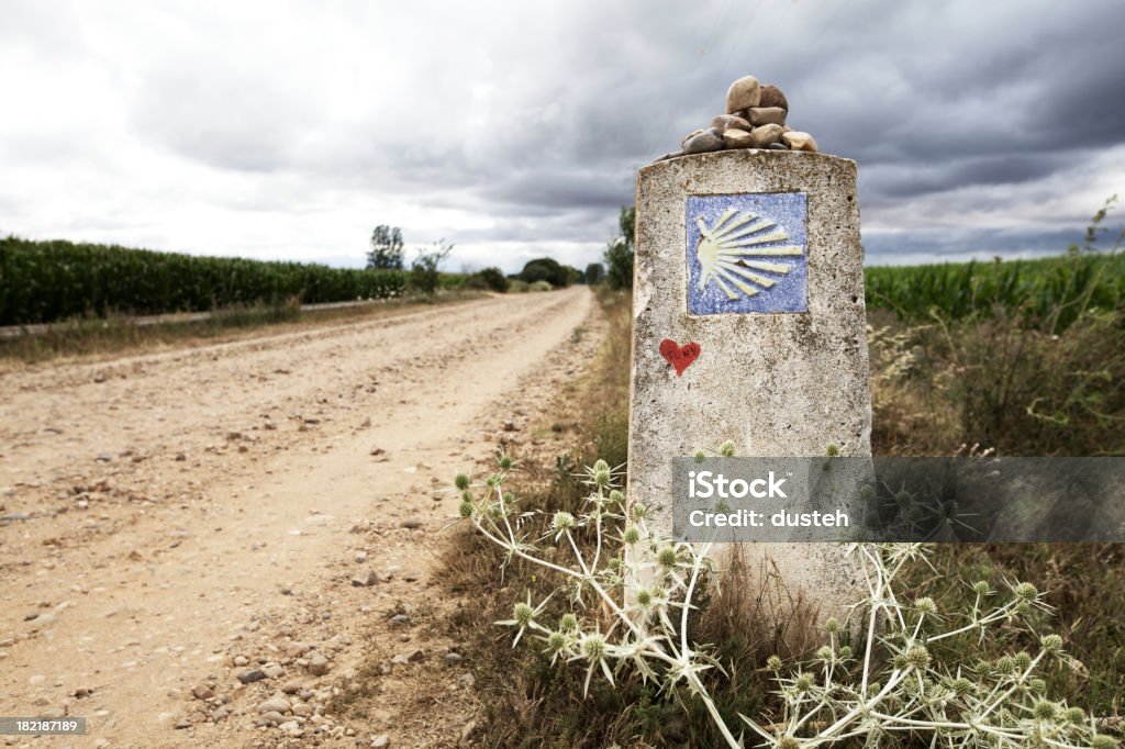 Milestone on the way of Saint James "Milestone with the Saint James Shell on it, showing that you are on the right path on the Way of Saint James (Camino de Santiago), shortly before Hospital the Orbigo (following the traditionel route).As typically for the Way of St. James, pilgrims have put some small stone on it.See more pictures from the St. James way:" Camino De Santiago Stock Photo