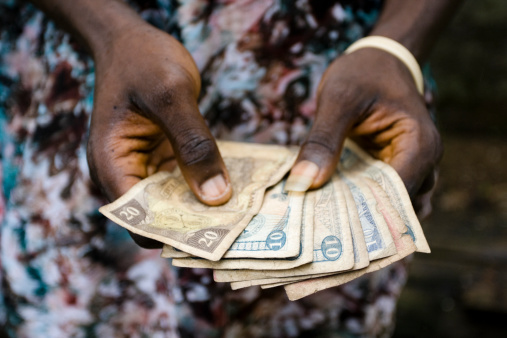 Hands holding Liberian money