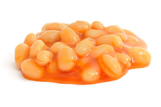 Pile of baked beans on a white background A small pile of Baked Beans isolated on white. baked beans stock pictures, royalty-free photos & images