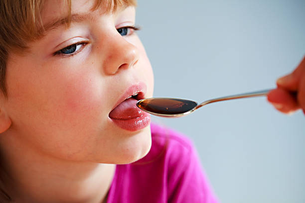 istock Girl taking medicine from a spoon 182187269