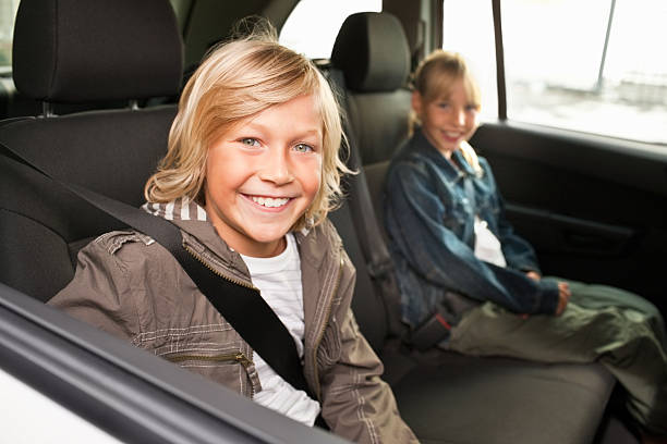 istock Boy and girl smiling while sitting in a car 182187295