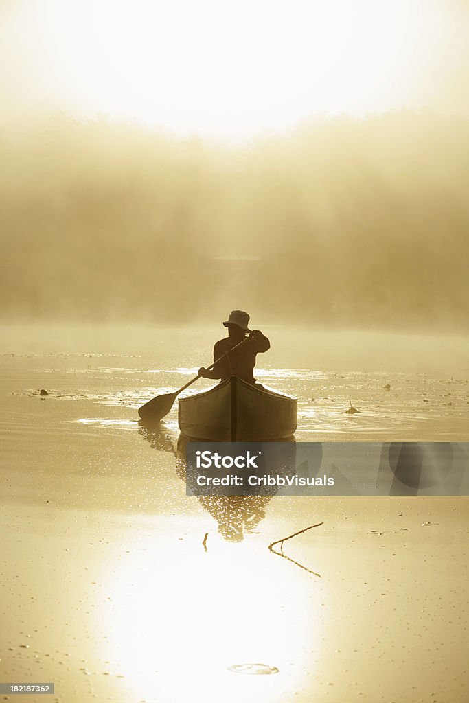 Garota ao ar livre, o remo canoa no lago no misty sunrise com iluminação de fundo - Foto de stock de Canoa royalty-free