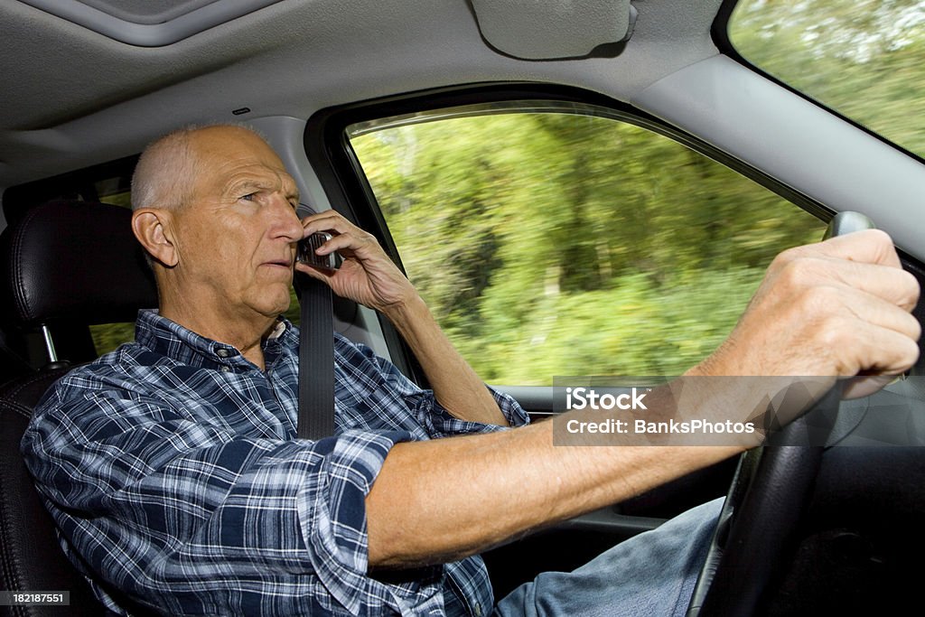 Hombre mayor conducción y usando un teléfono móvil - Foto de stock de Interior del coche libre de derechos