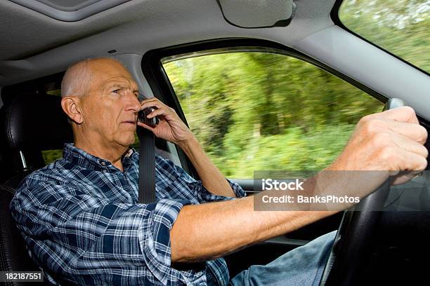 Hombre Mayor Conducción Y Usando Un Teléfono Móvil Foto de stock y más banco de imágenes de Interior del coche - Interior del coche, Teléfono para coche, 60-69 años