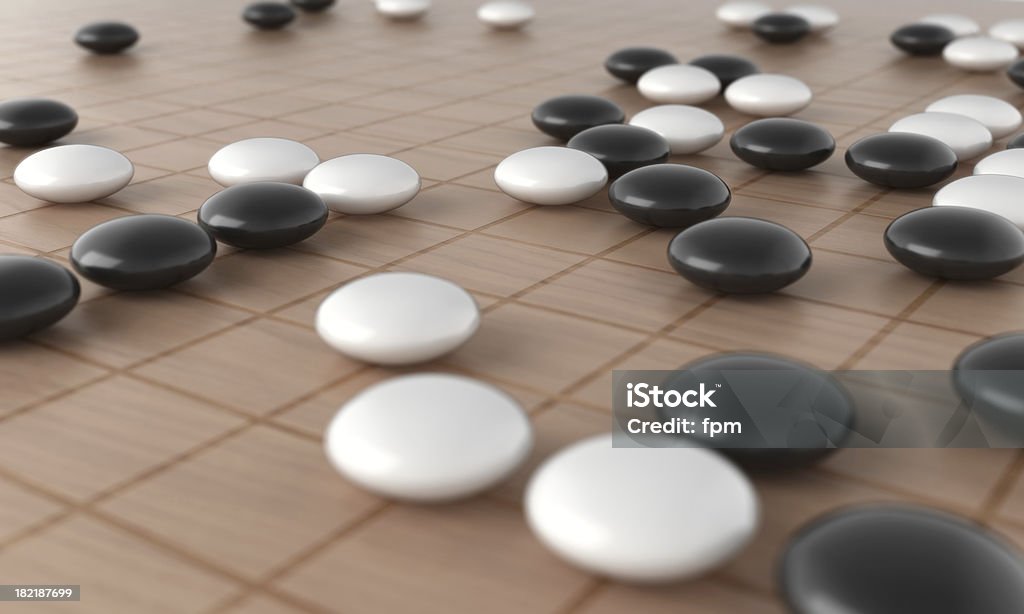 Go Game Royalty-free image of wooden Go Game board with black and white tokens. Focus on centered stones. Go - Board Game Stock Photo