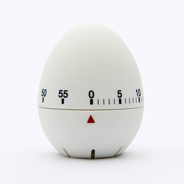 White egg-shaped kitchen timer isolated on white background Kitchen egg timer. timer photos stock pictures, royalty-free photos & images