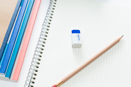 Notebook and writing utensils on a white background.