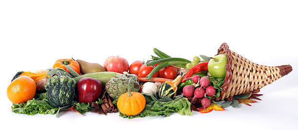 Cornucopia with fresh fruits and vegetables isolated on white "Assorted fruits and vegetables in a cornucopia basket. Includes squash, apples, radishes, onions, peppers, greens and gourds. Isolated on white including copy space. Cornucopias are associated with Thanksgiving but could also be used for diet and healthy eating with colorful food." thanksgiving full stock pictures, royalty-free photos & images