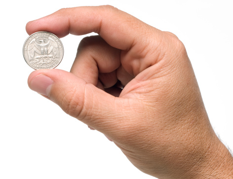A quarter dollar coin being held by a male's hand.