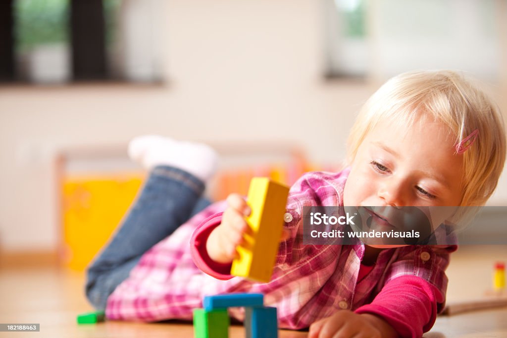 Menina feliz brincando com blocos é - Foto de stock de Bloco de construção royalty-free