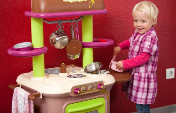 istock girl is playing in her toy kitchen 182188469