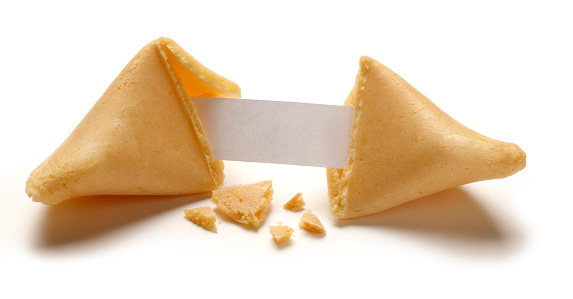 A fortune cookie is broken in half revealing a blank fortune inside.  Crumbs are scattered below and around the broken cookie.  Text can be added to the blank fortune. Image is isolated on white with a soft drop shadow.