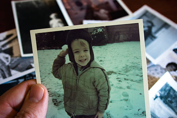 hand, die hält vintage foto mit jungen im schnee - family tree family photograph photography stock-fotos und bilder