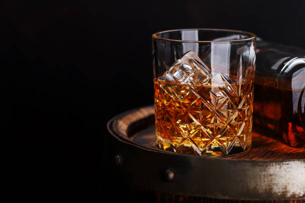 istock Whiskey glass with ice on a rustic barrel, a classic sip 1821907225