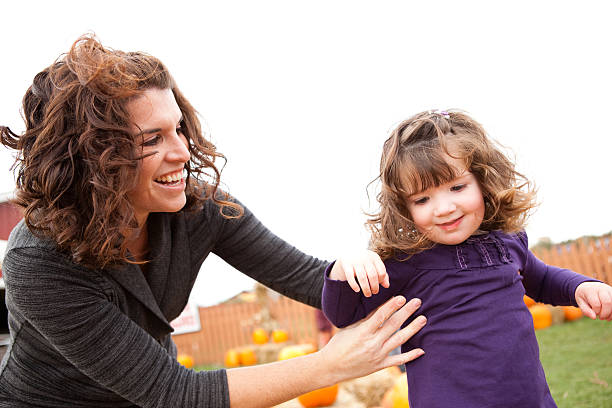 istock Happy Mother and Daughter in a Pumpkin Patch 182190931