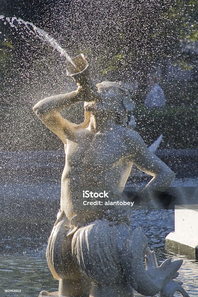 Savannah GA: Fountain in Forsythe Park (detail) Savannah GA: Fountain in Forsythe Park (detail) with Poseidon figure.  This public art was installed in 1858. Water droplets with short motion blur in back-light. Art Stock Photo