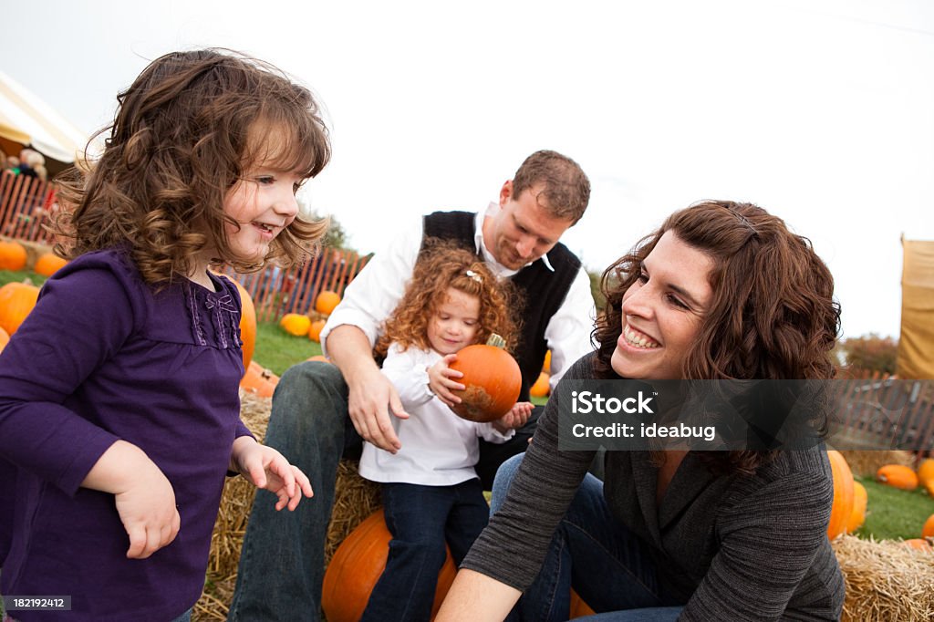 Feliz familia de cuatro en una parcela de calabaza - Foto de stock de Heno libre de derechos