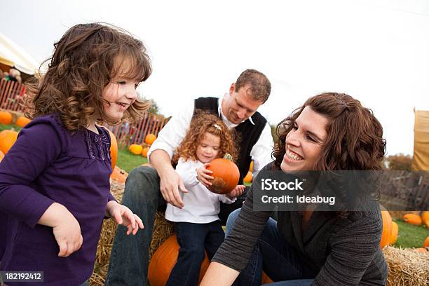 Feliz Familia De Cuatro En Una Parcela De Calabaza Foto de stock y más banco de imágenes de Heno - Heno, Otoño, 2-3 años