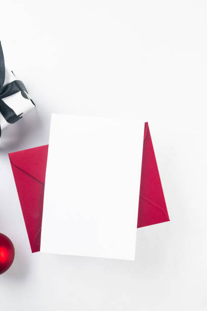 istock White empty paper card mockup space in envelope with Christmas gifts boxes and baubles. Xmas invitation, flyer or greeting card mock up. 1821925388
