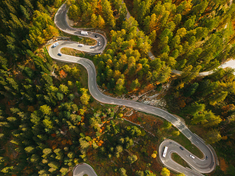 Scenic aerial view of  serpentine road (Majola Pass) in mountains  in autumn with traffic on it