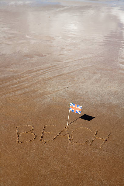 istock Small Union Jack flag with 'Beach' written in the sand 182193825