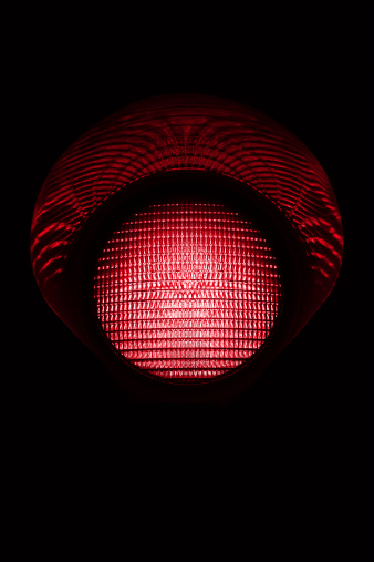 Red traffic light in the dark. Other traffic lights in: