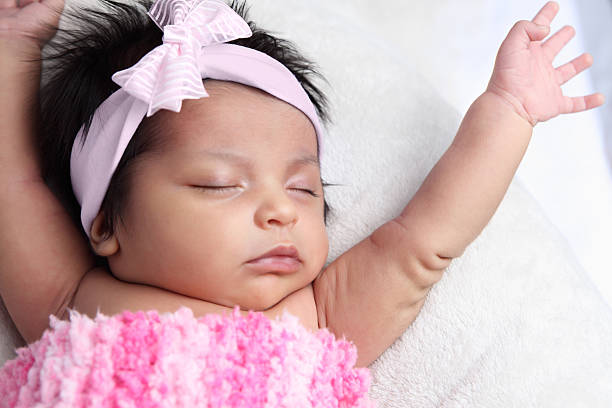 Stretching newborn "Stretching newborn baby wrapped in pink blanket, wearing pink hairbow." bow baby girls hair bow head and shoulders stock pictures, royalty-free photos & images