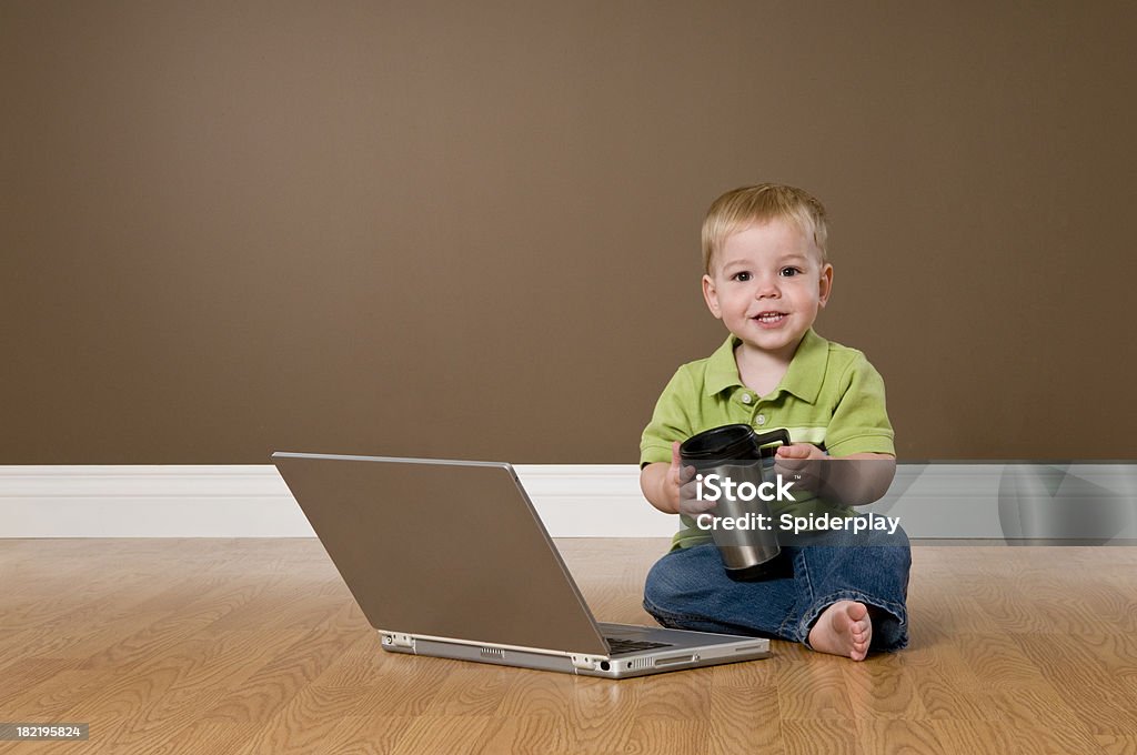 Toddller avec ordinateur portable et tenant une tasse de café - Photo de 12-17 mois libre de droits