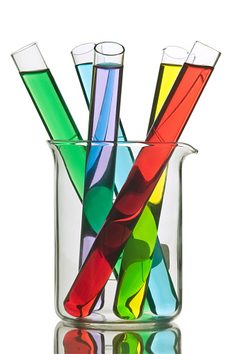glass in a chemical laboratory filled with liquid of many colors during the reaction.
