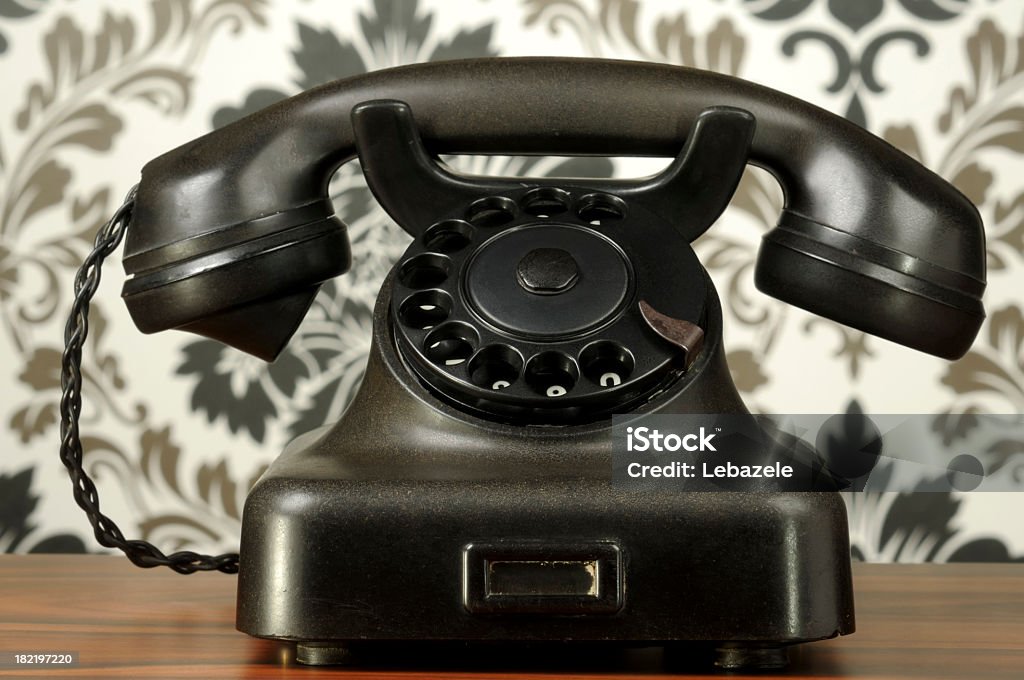 Vintage Phone Vintage phone in front of vintage wallpaper. Antique Stock Photo