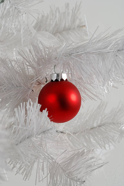 red Christmas ornament on a white tree stock photo