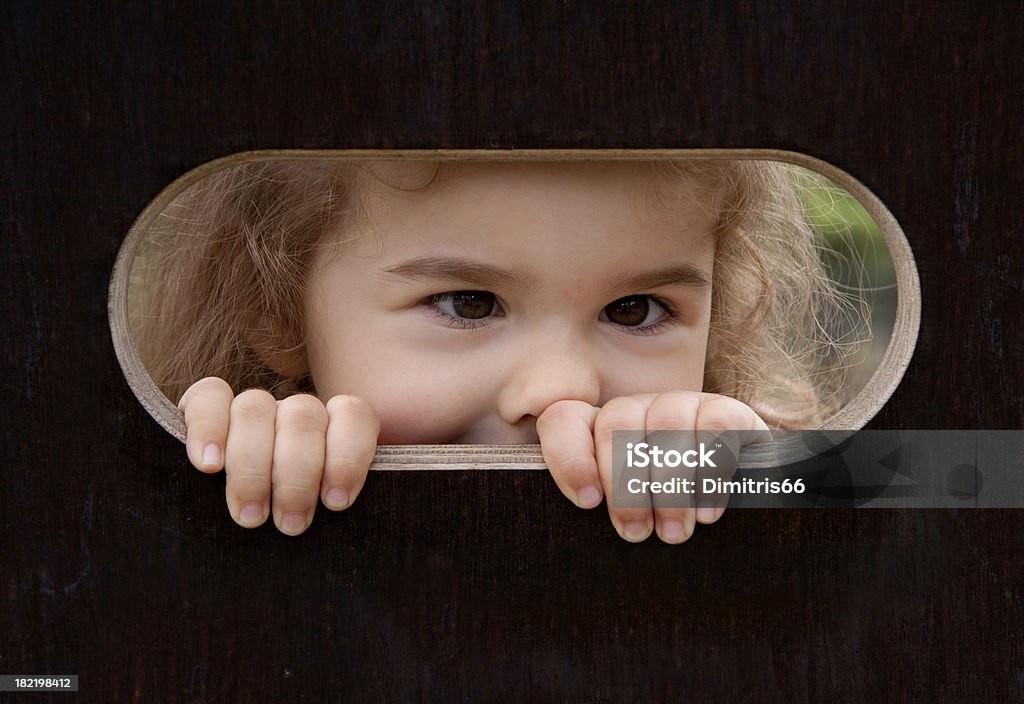 Esconde-esconde. Menina olhando para fora - Foto de stock de Criança royalty-free