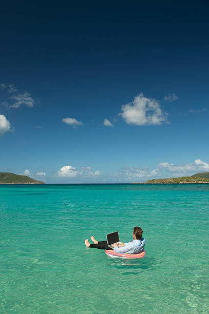 istock Businessman Floating Typing on Laptop in Tropical Bay 182198773