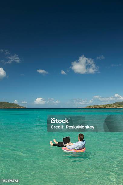 Biznesmen Pływające Wpisując Na Laptopie W Tropikalnej Bay - zdjęcia stockowe i więcej obrazów Białe kołnierzyki