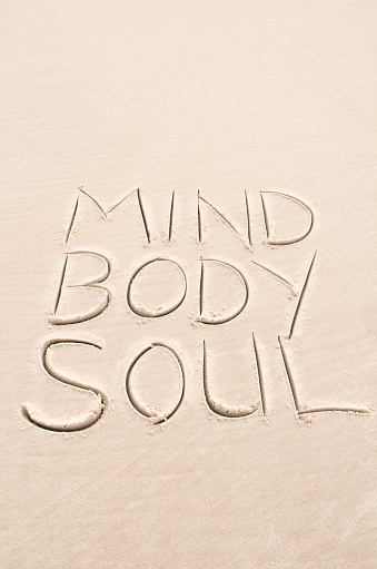 Simple message of inspiration in sand spells out Mind Body and Soul